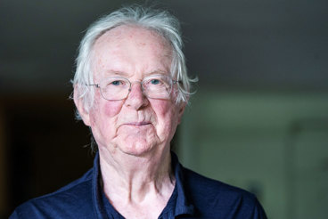 Portrait von Fulbert Steffensky. Weisse, kurze Haare, blaue Augen, Brille. Seine sehr helle Haut ist gerötet, er trägt ein dunkelblaues Poloshirt und lächelt verhalten verschmitzt in die Kamera