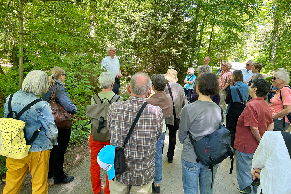 Pfarrer Markus Sieber führt die rund 30 Teilnehmenden durch die Geschichten der Menschen, die auf dem Schaffhauser Waldfriedhof begraben sind. | Foto: zvg