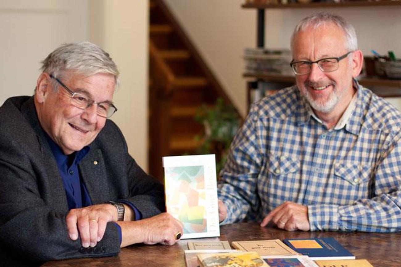 Markus B. Christ (links), Präsident der Bibelgesellschaft Baselland, und Hansueli Müller, Leiter des Übersetzungsteams, mit der druckfrischen Ausgabe des Johannesevangeliums auf Baselbieterdeutsch. | kim/Kirchenbote